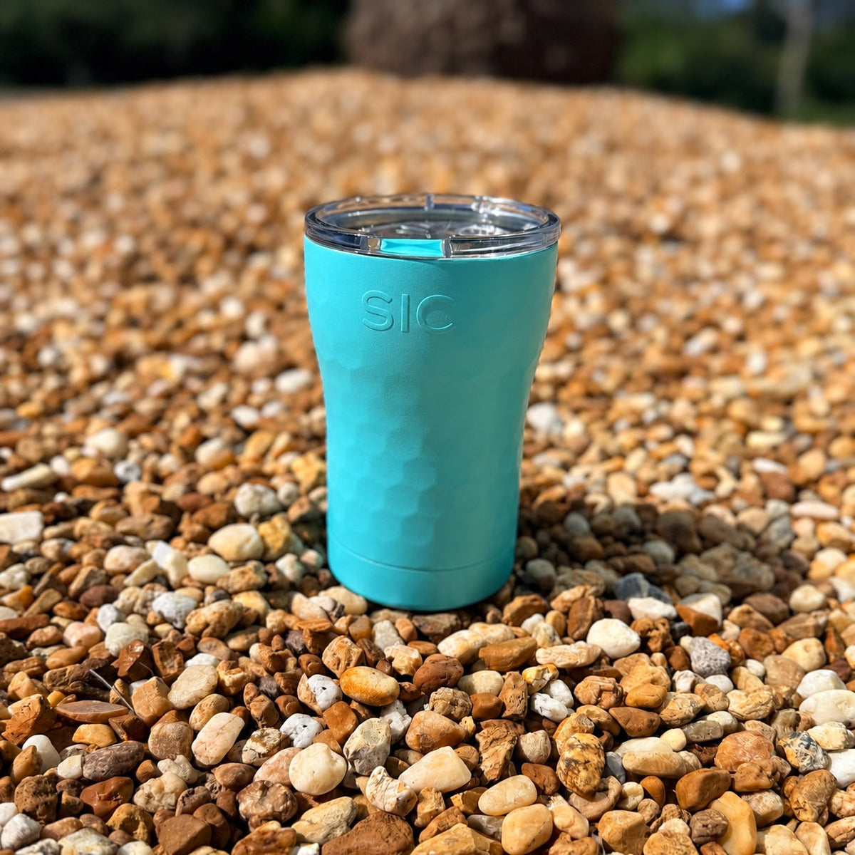 SIC Hammered Seafoam 12 oz. tumbler on pebbles