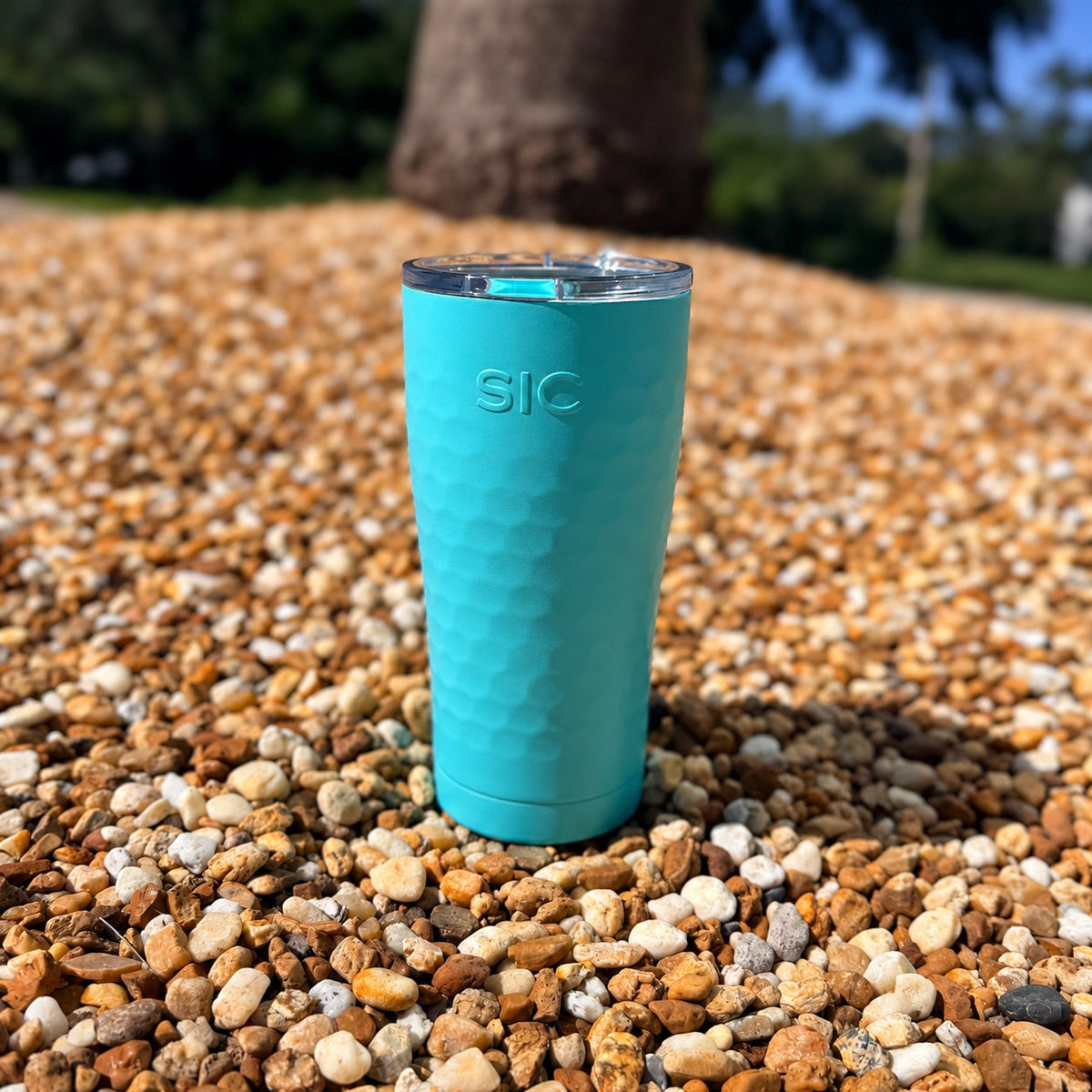 SIC Hammered Seafoam 20 oz. tumbler on pebbles