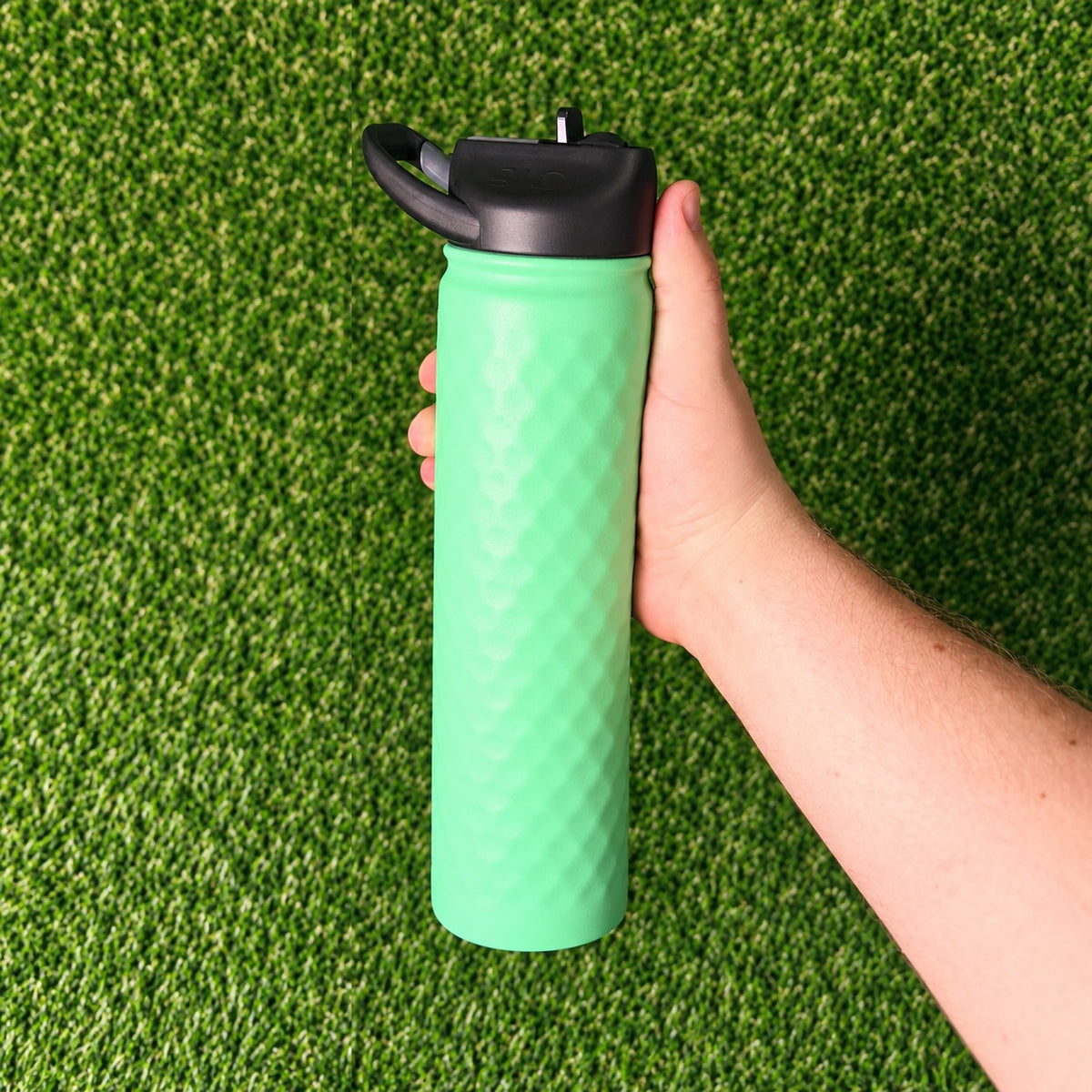Hand holding a SIC Hammered Mint 27 oz. sport bottle with black lid