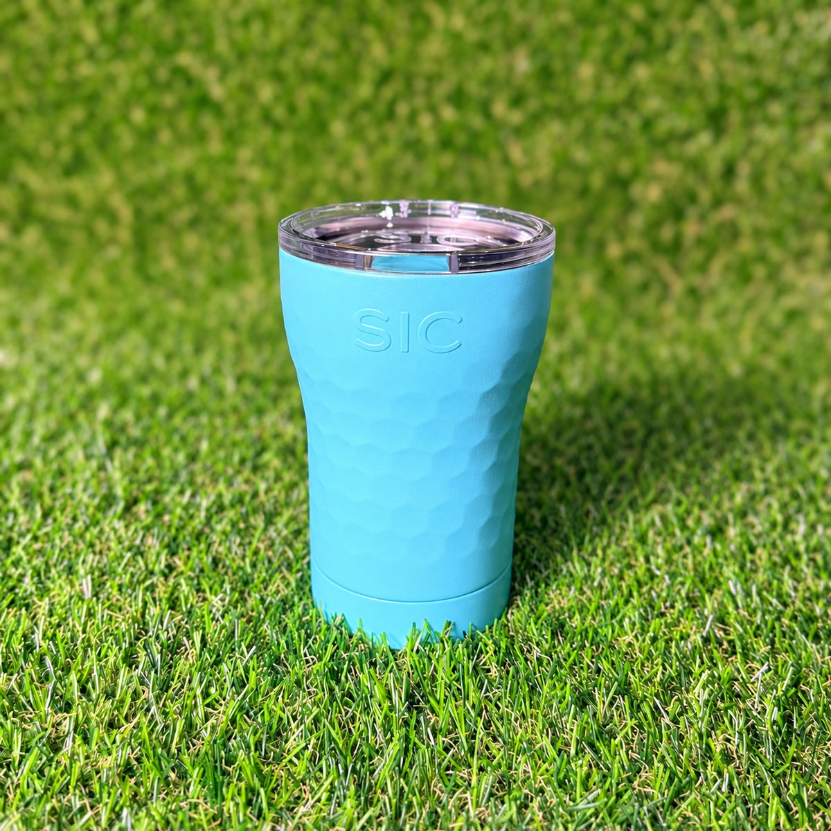 SIC Hammered Seafoam 12 oz. tumbler with clear lid on green turf